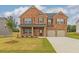 Two-story brick home featuring a well-manicured lawn, two-car garage, and inviting front porch at 300 Bianca Way, Mcdonough, GA 30253