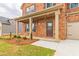 Covered front porch with brick columns, neutral door, and landscaped flower bed at 300 Bianca Way, Mcdonough, GA 30253