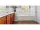 Bathroom with a soaking tub, wood cabinets, tile flooring, and natural light at 308 Helena Pl, Mcdonough, GA 30252