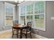 Bright breakfast nook with a round wooden table, chairs, and views of the outdoors through large windows at 308 Helena Pl, Mcdonough, GA 30252