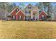 Beautiful two-story brick and tan home with manicured lawn and mature trees at 308 Helena Pl, Mcdonough, GA 30252