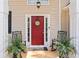 Inviting front door with a decorative wreath, rocking chairs, and potted plants at 308 Helena Pl, Mcdonough, GA 30252