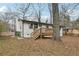 A home's back exterior with a deck overlooking a foliage-filled yard at 1700 Shirley Sw St, Atlanta, GA 30310