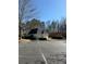 View of the community clubhouse with a parking lot, dark roof, and trimmed landscaping at 3331 Freedom Nw Lndg, Kennesaw, GA 30144