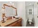Updated bathroom boasts a vessel sink, vintage vanity, and a shower-tub combo at 5130 Forest Hills Ct, Cumming, GA 30041