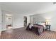 Comfortable bedroom featuring brick floors, view to bathroom and walk-in closet; neutral tones at 5130 Forest Hills Ct, Cumming, GA 30041