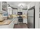 Updated kitchen features stainless appliances, white cabinetry, and granite countertops at 5130 Forest Hills Ct, Cumming, GA 30041