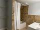 Bathroom featuring a shower-tub combo, vanity, and modern fixtures with tiled walls at 1298 Belmont Se Ave, Smyrna, GA 30080