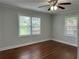 Bedroom features wood floors, neutral paint, ceiling fan, and two windows at 1298 Belmont Se Ave, Smyrna, GA 30080