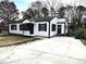 Charming home featuring a white exterior with black trim, a concrete driveway, and a well-maintained front yard at 1298 Belmont Se Ave, Smyrna, GA 30080