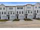 New construction townhomes featuring white siding, black trim, individual garages, and professional landscaping at 3151 Washburn Sw St, Atlanta, GA 30354