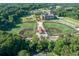 Aerial view of two baseball fields near a brick school building and a wooded area at the Brook Run Park at 4696 Dunover Cir, Dunwoody, GA 30360