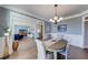 Well-lit dining room with hardwood floors, chandelier, and open view into a comfortable living space at 6055 Climbing Rose Way, Cumming, GA 30041