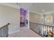 Bright hallway with natural light, decorative railing, and neutral wall color enhances the home's elegant aesthetic at 6055 Climbing Rose Way, Cumming, GA 30041