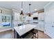 Bright kitchen features white cabinets, quartz countertops, stainless steel appliances, and dark island at 6055 Climbing Rose Way, Cumming, GA 30041