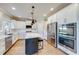 Bright kitchen features white cabinets, quartz countertops, stainless steel appliances, and dark island at 6055 Climbing Rose Way, Cumming, GA 30041