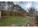 Spacious backyard featuring a wooden fence, green grass, and mature trees at 1307 Calderwood Se Ct, Smyrna, GA 30080