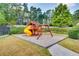 Community playground featuring a wooden playset with slide, swings, and a gravel base at 1307 Calderwood Se Ct, Smyrna, GA 30080