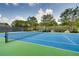 Well-maintained tennis court on a sunny day, surrounded by lush trees and a secure fence at 1307 Calderwood Se Ct, Smyrna, GA 30080
