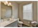 Well-lit bathroom featuring a gray vanity, toilet and window at 2137 Post Grove Rd, Snellville, GA 30078