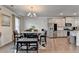 Dining area with a glass table, chandelier, and view of kitchen and stainless steel refrigerator at 2137 Post Grove Rd, Snellville, GA 30078