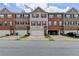 A street view of townhomes displaying diverse brick and siding exteriors, each with a garage at 2137 Post Grove Rd, Snellville, GA 30078