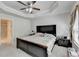 Relaxing main bedroom with tray ceiling, ceiling fan, and adjoining bathroom at 2137 Post Grove Rd, Snellville, GA 30078