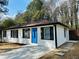 Renovated single-story home boasts a blue front door, fresh paint, and modern black window trim at 2745 Marco Nw Dr, Atlanta, GA 30318
