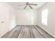 Bright bedroom featuring modern gray wood flooring, a ceiling fan, and ample natural light from the window at 1108 Sw Welch Sw St, Atlanta, GA 30310