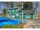 Charming green two-story home with a white front door and covered in a blue tarp at 1444 Norman Berry Dr, East Point, GA 30344