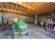View of unfinished garage with lawn equipment and exposed wood ceiling at 1444 Norman Berry Dr, East Point, GA 30344