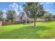 Large grassy backyard featuring a patio area, a wooden fence, and mature trees at 117 Kiara Ln, Stockbridge, GA 30281