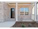 Welcoming front entrance with a brick facade, white columns, and a stylish black front door at 431 Crestmont Ln, Canton, GA 30114