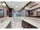 Stylish bathroom featuring dual sinks, dark wood cabinets, and a tiled glass shower at 604 Ansley Villa Ne Dr, Atlanta, GA 30324