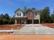 Two-story home featuring brick and vinyl siding with an attached two-car garage and newly poured concrete driveway at 1590 Sungrown Way, Mcdonough, GA 30253