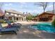 Spacious backyard with a pool, lounge area, cabana, and mature trees, offering a private outdoor oasis at 6715 Brookline Ct, Cumming, GA 30040