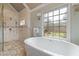 Bright bathroom with a soaking tub, a large window, and a glass enclosed shower at 6715 Brookline Ct, Cumming, GA 30040
