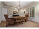 Elegant dining room with tray ceiling, plantation shutters, and a wood table at 6715 Brookline Ct, Cumming, GA 30040