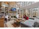 Bright living room with a stone fireplace, built-in shelving, and backyard views at 6715 Brookline Ct, Cumming, GA 30040