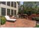 Charming brick patio with lounge chair, table, and green landscaping offers a serene outdoor space at 6715 Brookline Ct, Cumming, GA 30040