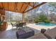 Beautiful outdoor patio featuring a covered seating area and a gorgeous pool view with flowering trees at 6715 Brookline Ct, Cumming, GA 30040