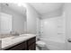 Bathroom featuring granite countertop, dark wood cabinet, tub and shower with storage shelves at 6117 Summerstone Ln, Douglasville, GA 30135