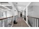 Upstairs hallway with iron railing, coffered ceiling, and abundant natural light at 6117 Summerstone Ln, Douglasville, GA 30135