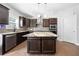 Modern kitchen with island, stainless steel appliances, and dark wood cabinets at 6117 Summerstone Ln, Douglasville, GA 30135
