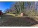 Large grassy backyard with a storage shed and mature trees, offering privacy at 6582 Malvin Dr, Mableton, GA 30168