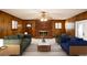 Cozy living room features wood paneling, a brick fireplace, and a ceiling fan for a warm and inviting atmosphere at 6582 Malvin Dr, Mableton, GA 30168