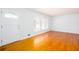 Bright living room featuring gleaming hardwood floors, white walls, and large windows with plantation shutters at 6582 Malvin Dr, Mableton, GA 30168