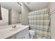 Well-lit bathroom with a vanity, toilet, and a shower featuring a decorative shower curtain at 6690 Cold Stream Dr, Cumming, GA 30040