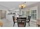 Cozy dining area featuring a chandelier, large windows, and an open view to the modern kitchen at 6690 Cold Stream Dr, Cumming, GA 30040