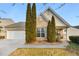 Charming brick home featuring manicured front yard with mature landscaping, and an attached two-car garage at 6690 Cold Stream Dr, Cumming, GA 30040